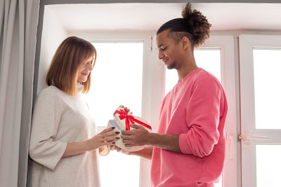 A young man gives a girl a gift box in the form of a heart