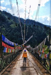 Rear view of people on mountain road against sky