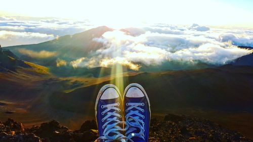 Low section of woman against mountains during sunset