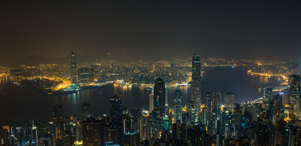 Illuminated cityscape against sky at night