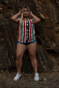 Full length of young woman standing on rock