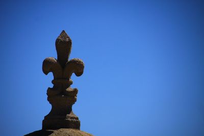 Low angle view of sculpture against clear blue sky