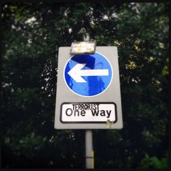 Low angle view of sign board against blue sky