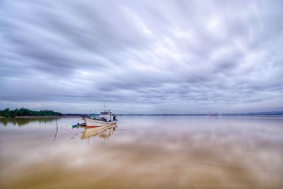 Fishing boat in sea against sky