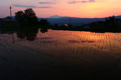 Scenic view of lake against sky during sunset