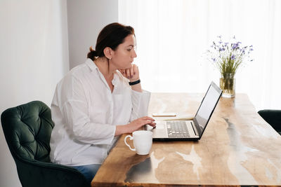 Middle age woman freelancer is working at home. pretty plus size female in 40s working with laptop