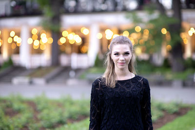 Portrait of a cute and gorgeous young woman on blurred strret background with bokeh light