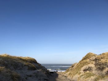 Scenic view of beach against clear blue sky