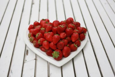 Close-up of strawberries in heart shape plate on table