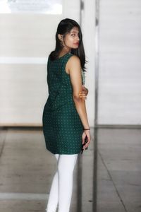 Portrait of woman standing against wall