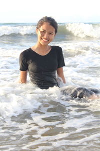 Portrait of smiling woman sitting in sea