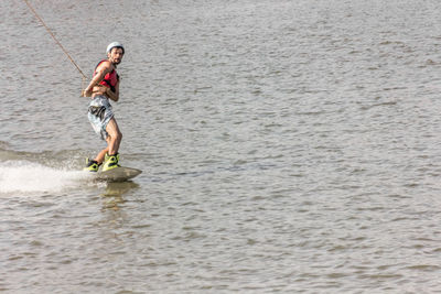 Full length of smiling man standing in sea