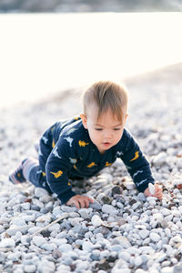 Cute boy on pebbles