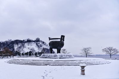 Built structure on snow covered landscape against sky