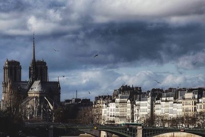 View of cityscape against cloudy sky