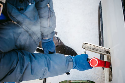 Low section of person refueling in car