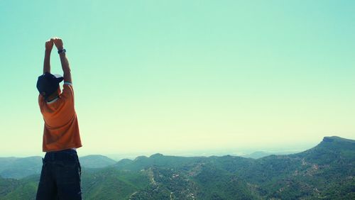 Woman standing on landscape against clear sky