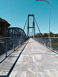 View of footbridge against clear blue sky