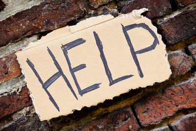 Close-up of help text on brick wall