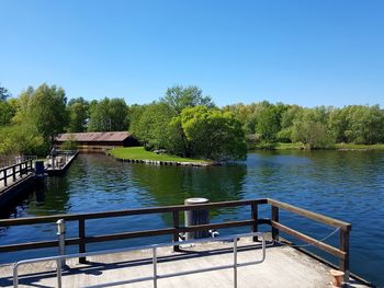 Scenic view of river against clear blue sky