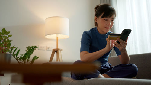 Young woman using mobile phone at home