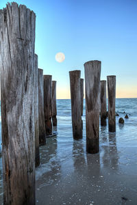 Dilapidated pier leading into the ocean on the beach of port royal in naples, florida at sunrise 