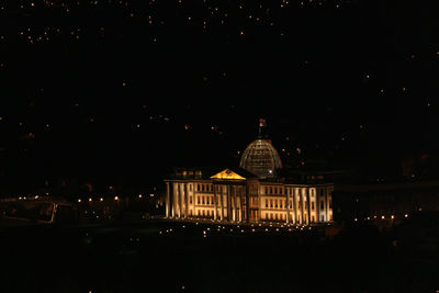 Illuminated building against sky at night