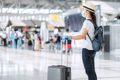 Side view of a woman standing at airport