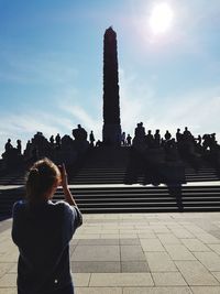 Rear view of people at historical building against sky