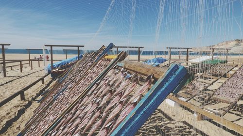 Fishing nets on beach against sky