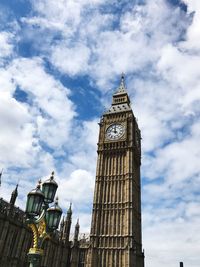 Low angle view of clock tower against cloudy sky