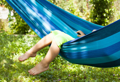 Side view of boy relaxing on hammock