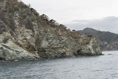 Rock formations by sea against sky