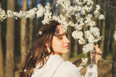 Portrait of young beautiful woman among flowering trees. fashion and beauty. spring concept