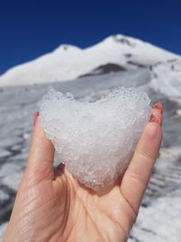 Close-up of hand holding snow