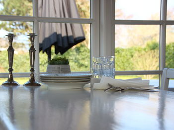 Close-up of glass on table against window