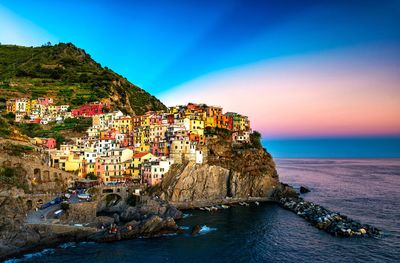 Scenic view of sea by buildings against sky