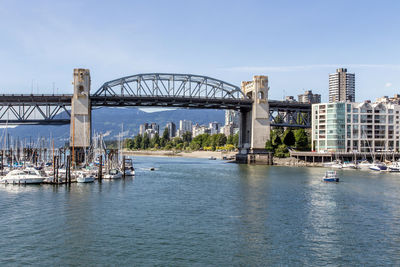 Burrard street bridge over false creek in city against sky