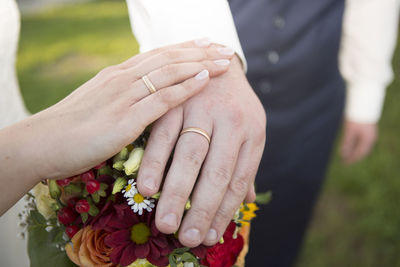 Midsection of bride holding bouquet