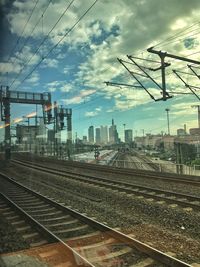 Railroad tracks in city against sky