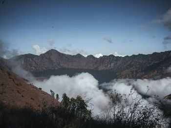 Smoke emitting from volcanic mountain against sky