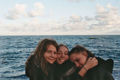 Portrait of smiling women against sea and sky