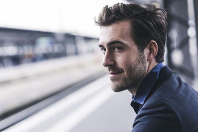 Young businessman waiting at station platform