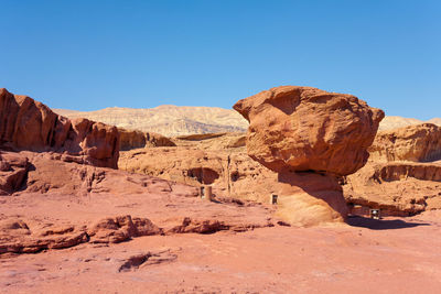 Rock formations in desert against clear blue sky