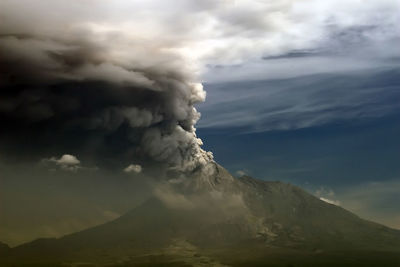 Scenic view of volcanic mountain against cloudy sky