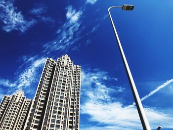 Low angle view of modern buildings against blue sky