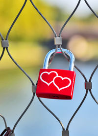 Close-up of love lock hanging on fence