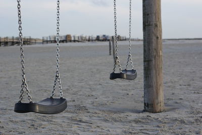 Close-up of swing in playground against sky