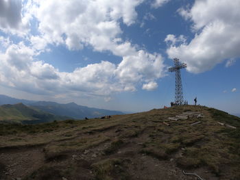 Low angle view of communications tower on land against sky