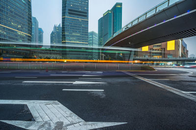 Light trails on road by buildings in city